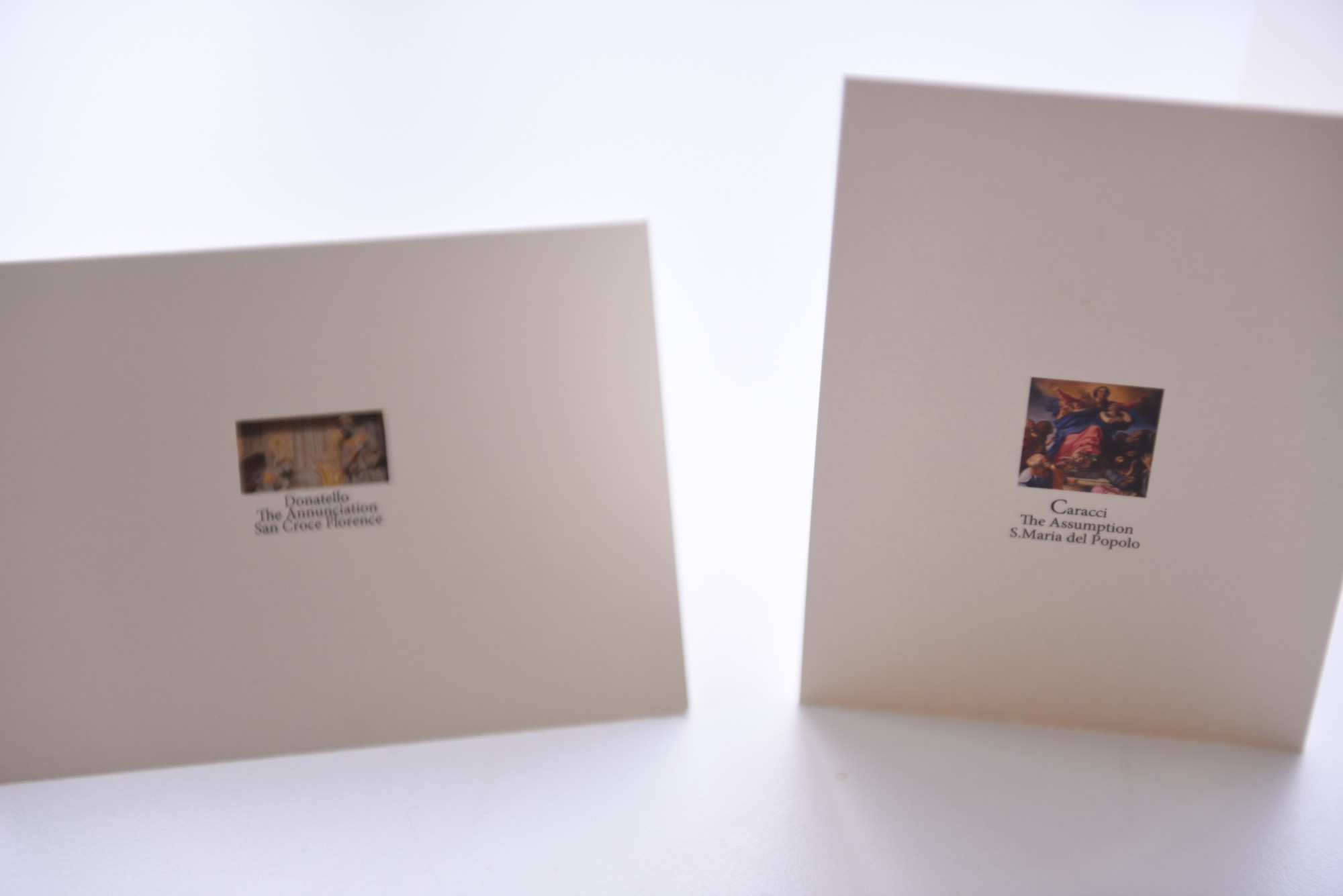 The backs of two greeting cards, each with a small image and a caption naming the artist, work, and church