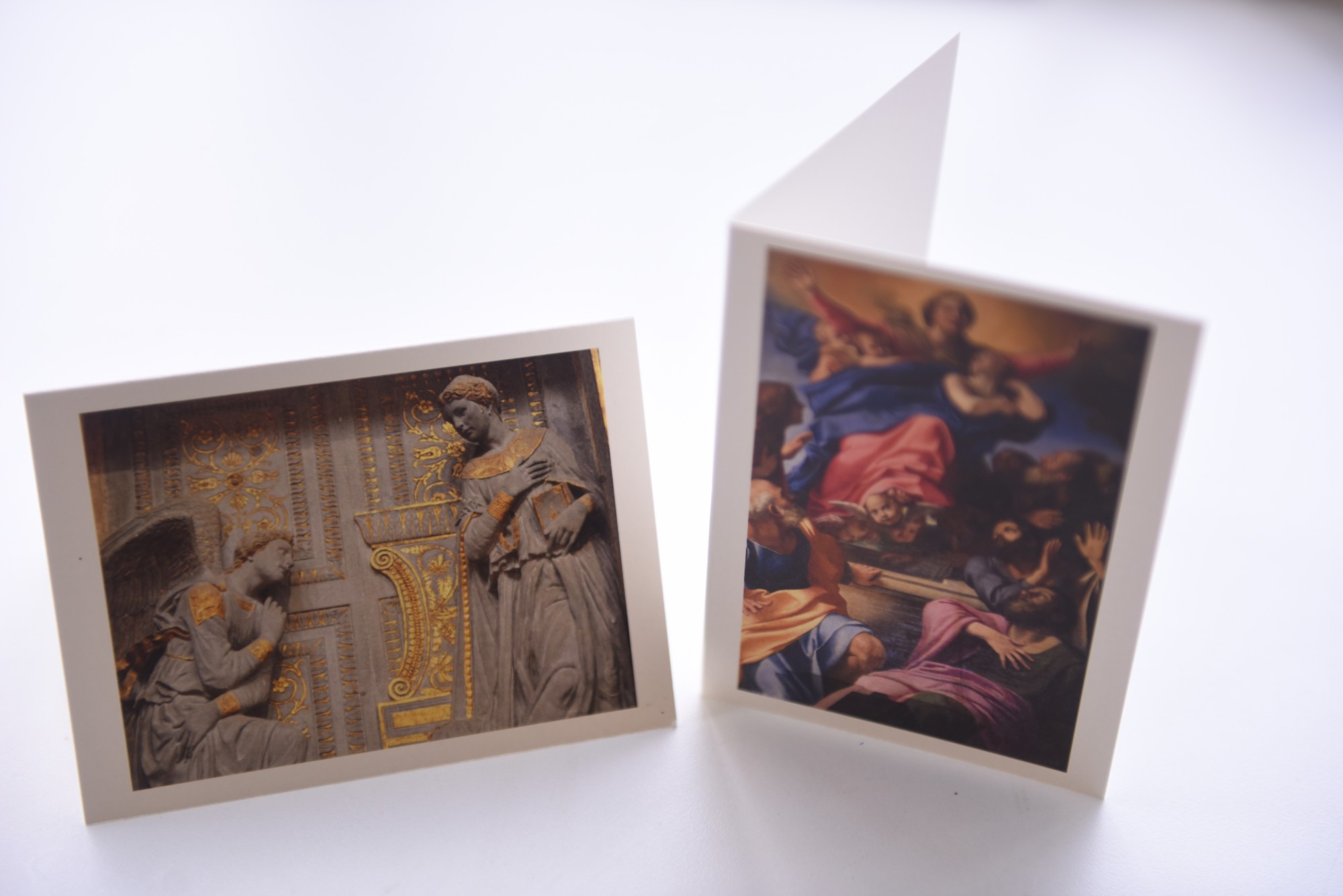Two folded greeting cards standing upright, each with a photograph mounted on the front